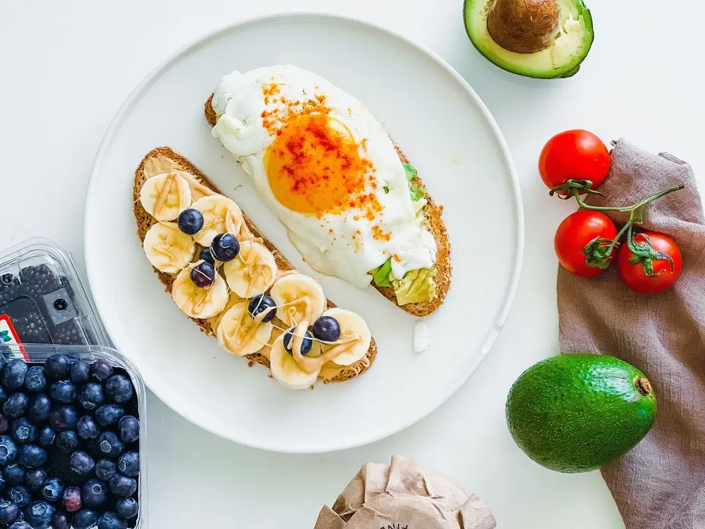 Egg, banana, and blueberry toast with avocado and tomatoes — energy-boosting foods for a busy day