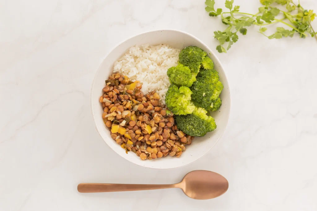 Bowl of cooked lentils and broccoli, two high-fiber foods that help you feel better all day